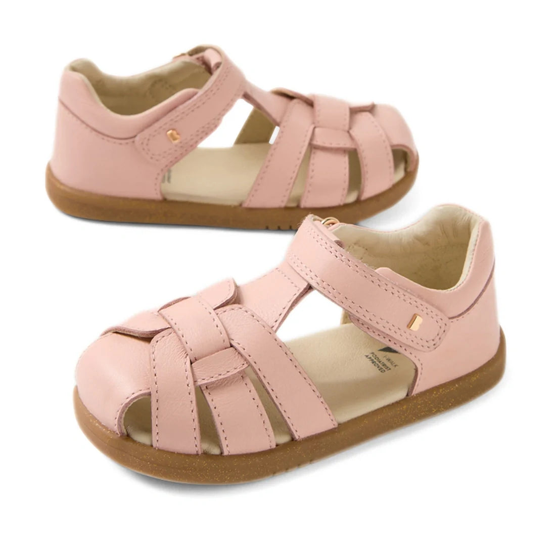 Two pairs of Bobux IWalk Skip Twist Sandal Cameo Rose Pink Closed Toe Toddlers with brown rubber soles, open toes, closed heels, and adjustable Velcro straps are displayed on a white background.