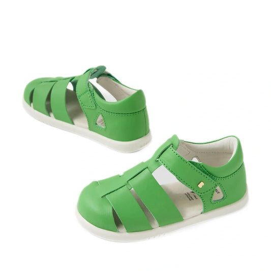 The Bobux IWalk Tidal Sandal Retro Green Closed Toe Toddlers are a pair of vibrant green sandals for toddlers, featuring closed toes, open sides, and Velcro straps. Made from water-friendly leather, they are shown against a white background.