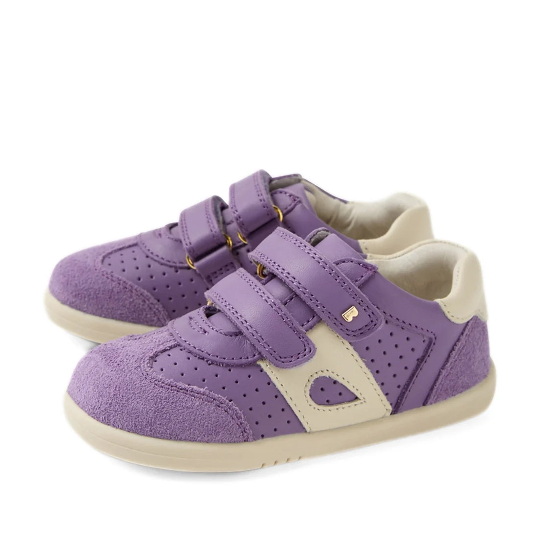 The Bobux IW Iwalk Toddlers Titan Purple Haze Leather Trainer features a stylish combination of purple and beige leather with perforated accents. Designed for comfort and security, each shoe is equipped with two adjustable velcro straps and slip-resistant