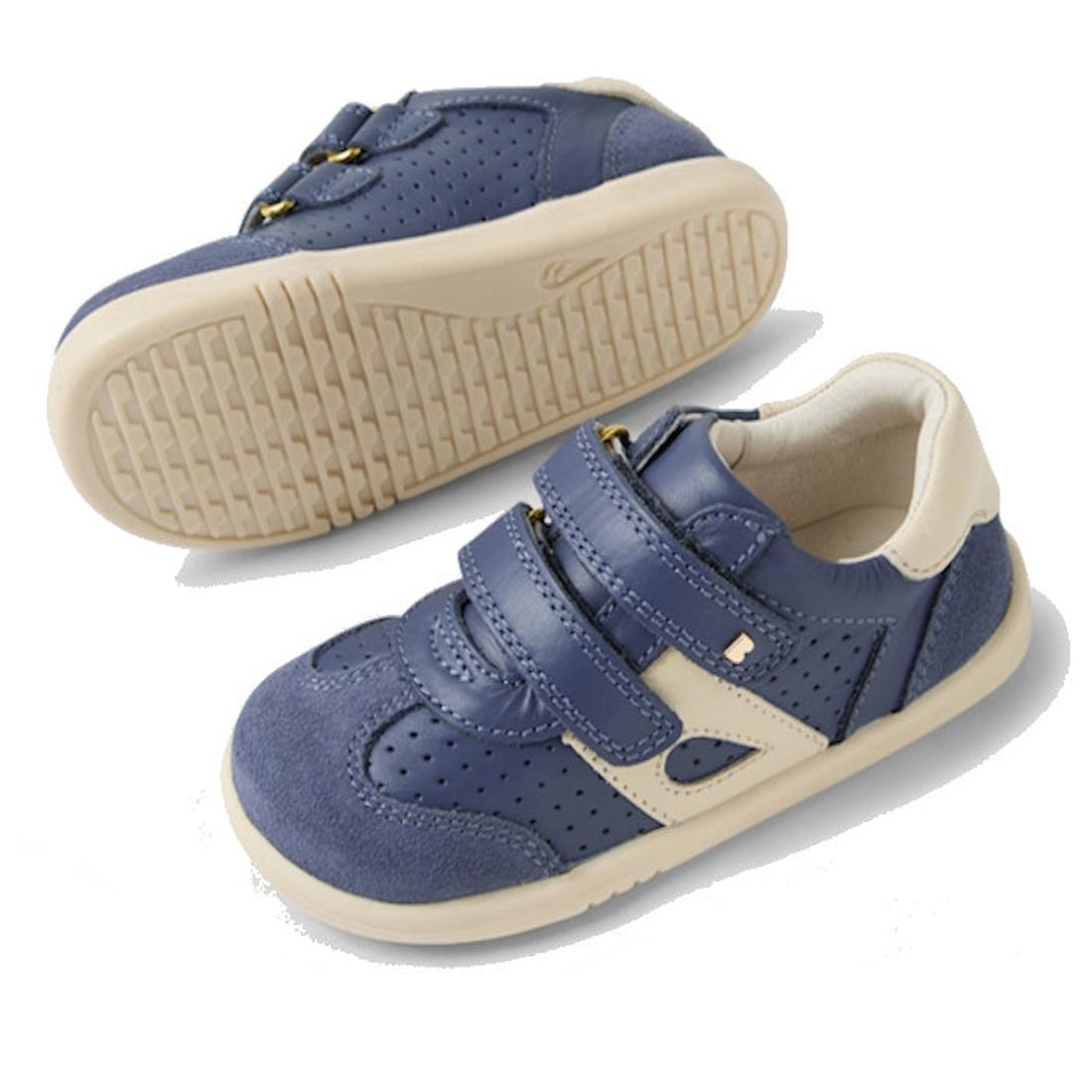The Bobux IW Iwalk Titan Leather Sneaker in White Vintage Indigo Blue features Velcro straps and rubber soles; one shoe is upright, the other on its side to show the tread. Available in various sizes for toddlers., 9420074854292, 9420074854308, 9420074854
