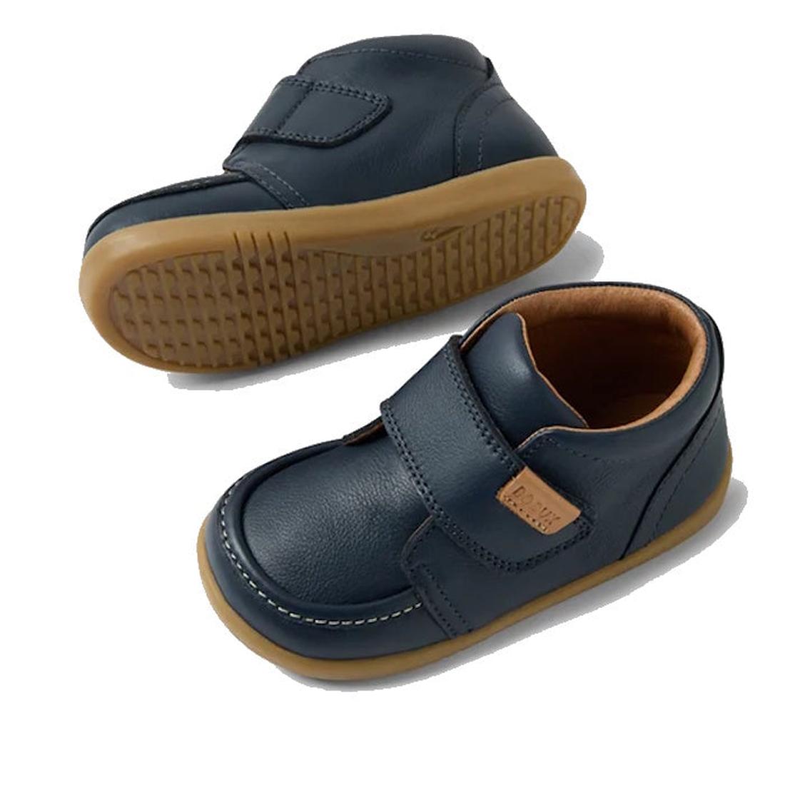 The Bobux IW Iwalk Grover Toddlers Navy Leather Boot features navy leather, tan rubber soles, white stitching, an adjustable Velcro strap closure, and a light brown inner lining, shown on a white background., 9420074832108, 9420074832115, 9420074832122, 9