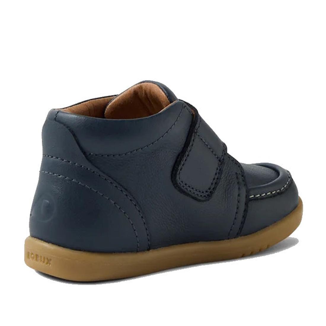 The Bobux IW Iwalk Grover Toddlers Navy Leather Boot features a tan rubber sole, visible stitching, and an adjustable strap. The kids' leather boot is pictured from the side and slightly behind., 9420074832108, 9420074832115, 9420074832122, 9420074832139,