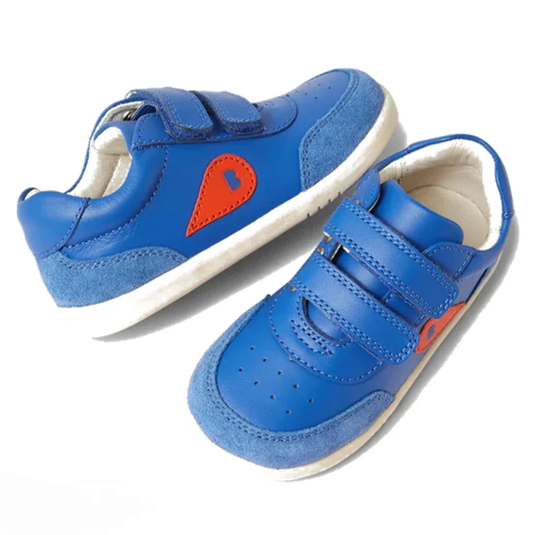 The Bobux IW Iwalk Champ Sneaker Olympian Blue is a blue toddler shoe with white soles, adjustable hook-and-loop straps, suede toe and heel accents, and orange teardrop-shaped side details.