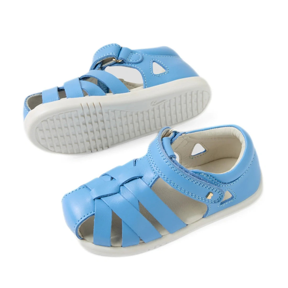 A pair of Bobux Iwalk IW Tropicana II Baltic Sea Blue leather sandals for toddlers, featuring closed-toe protection, open sides, and white rubber soles. One sandal is displayed upright while the other shows the sole., 9420074810250, 9420074810267, 9420074