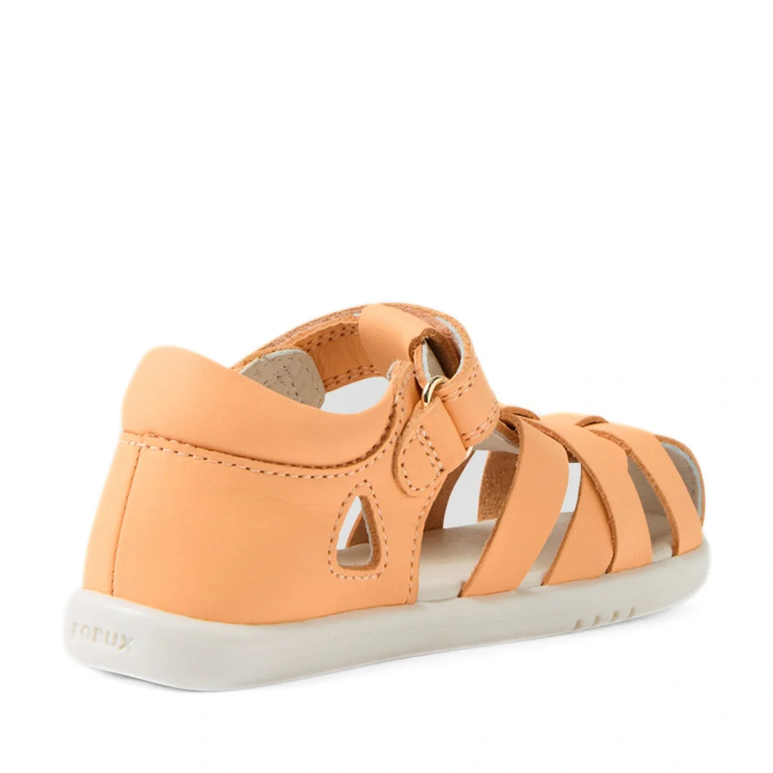 A peach-colored Bobux Iwalk IW Tropicana II Jelly Leather Sandal, viewed from the back right side, features a closed heel, white sole, and adjustable strap. This toddler sandal offers cutout details, stitched seams for added style and comfort, and provide