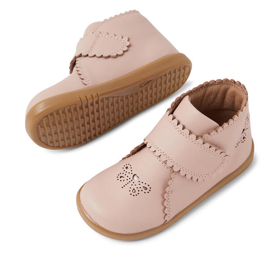 Two Bobux IW Iwalk Willow Leather Boot Cameo Rose Pink toddler shoes with brown rubber soles, scalloped edges, and a perforated butterfly on the toe. One shoe stands upright while the other shows its textured sole., 9420068545120, 9420068545137, 942006854