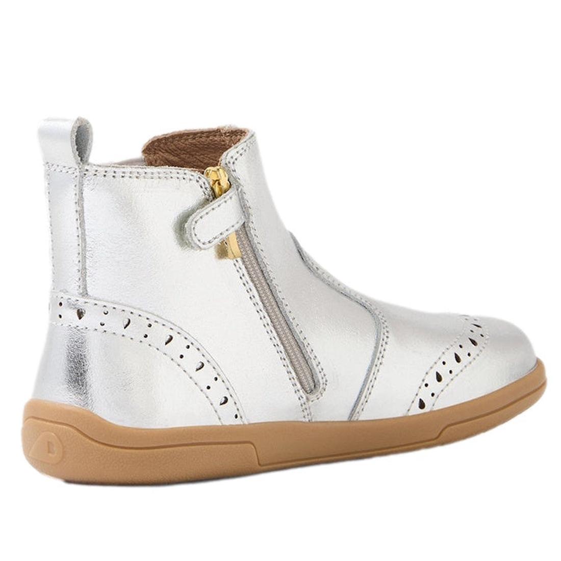 The Bobux Kid+ KP Billie 2 II Girls Leather Boot in silver features shiny leather, a flexible sole, tan rubber base, side zipper, decorative stitching, a small pull tab at the back, and classic brogue details for a comfortable, timeless style., 9420074867