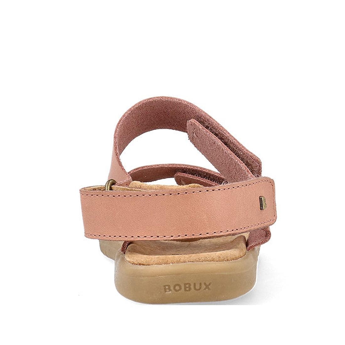 The Bobux Kid+ Plus Italian Clay Coast Open Toe Sandal 851201 is a pink leather kids' sandal with a back strap and Velcro closure. Featuring a light tan sole embossed with BOBUX, these breathable sandals are shown from the rear on a white background., 942