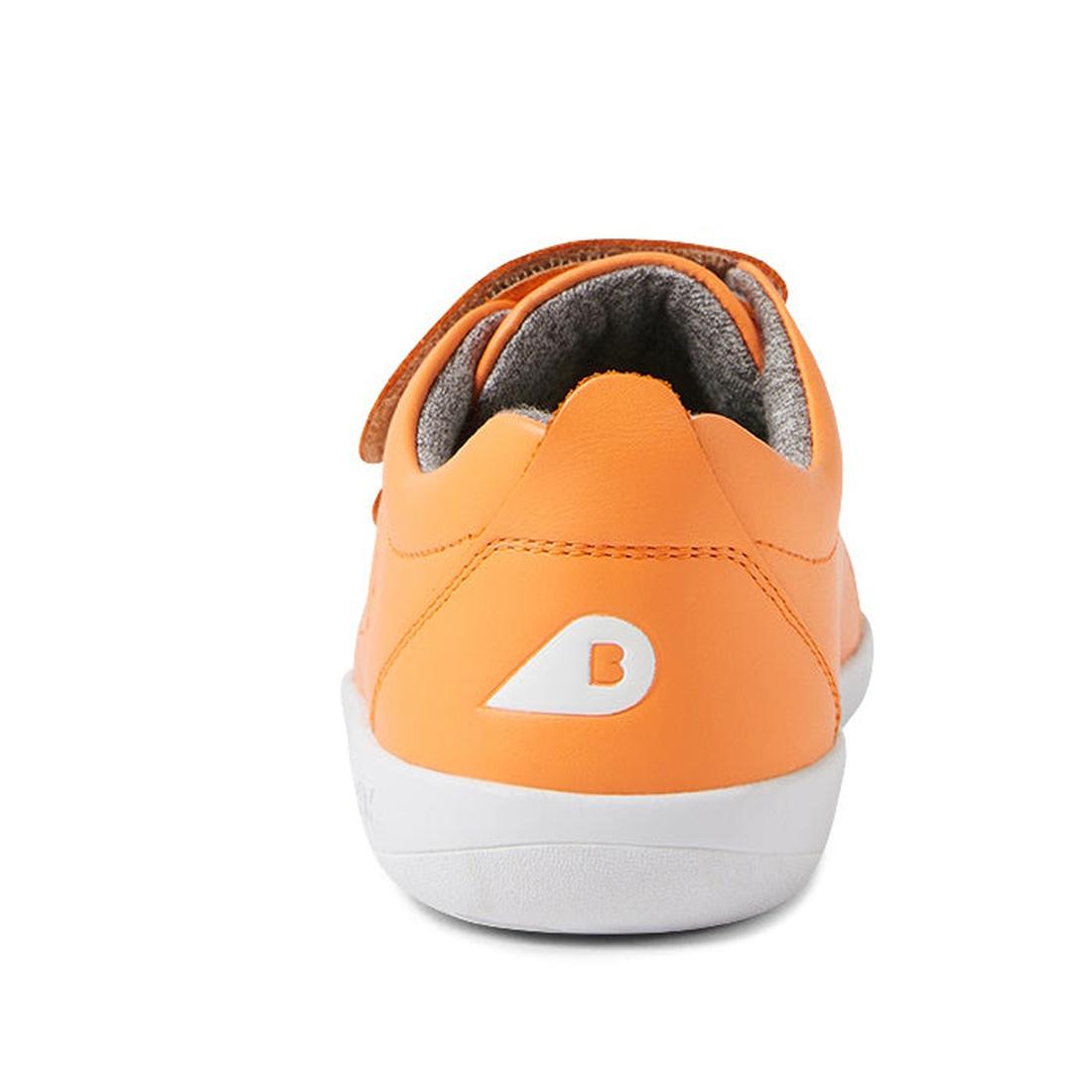 A rear view of the Bobux KP Kid Plus Grass Court Apricot Crush 841009 kids trainer shows its orange leather upper, white sole, double velcro straps, gray inner lining, and a white B logo on the heel., 9420075776265, 9420075777644, 9420075772717, 942007577