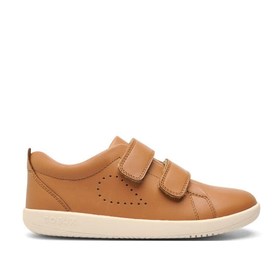 The Bobux Kids + Plus Grass Court Caramel Tan Velcro Trainers 832462 are tan leather shoes with double velcro straps, a wide opening, white sole, and side perforated pattern, shown in profile on a plain white background.