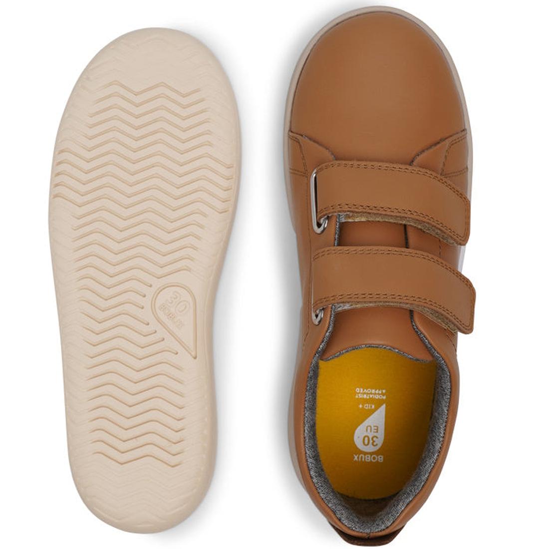 Bobux Kids + Plus Grass Court Caramel Tan Velcro Trainers 832462: a pair of caramel tan leather trainers for children with wide openings and double Velcro straps. One shoe is shown from above, the other displays a light, textured wavy-pattern sole., 94200