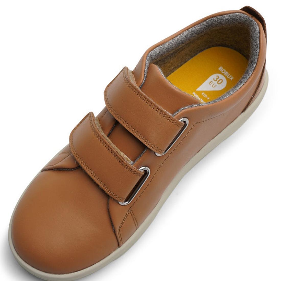The Bobux Kids + Plus Grass Court Caramel Tan Velcro Trainer 832462 is a children's tan leather shoe with a wide opening, double Velcro straps, white sole, and yellow insole, shown from above., 9420075792791, 9420071315963, 9420071315970, 9420071315987, 2