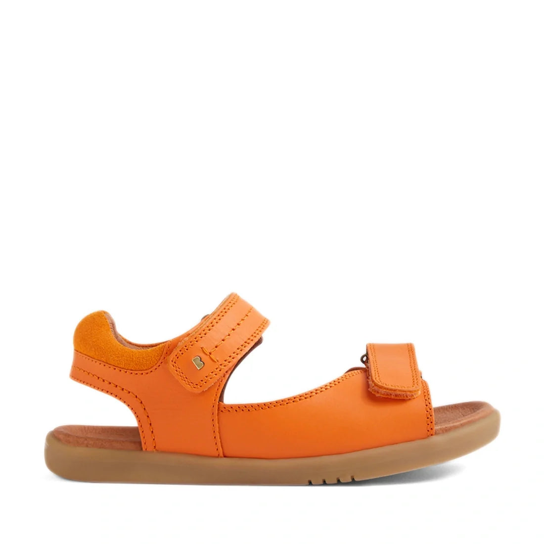 The Bobux KP Kids Plus Driftwood Leather Sandal in Orange Peel features adjustable Velcro straps at the ankle and toe, a brown cushioned footbed, and a light brown rubber sole. Shown in side profile on a white background, this children’s sandal is inspire