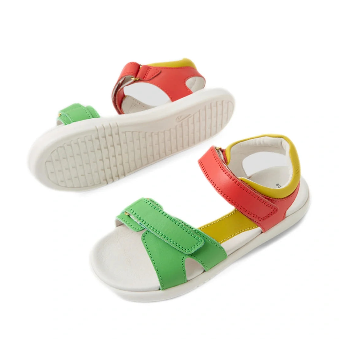 Two kids’ leather sandals with white soles: one features green and yellow straps, and the other showcases red and yellow straps. Both have open toes, cushioned footbeds, and adjustable hook-and-loop closures—delivering comfort just like the Bobux KP Kids 
