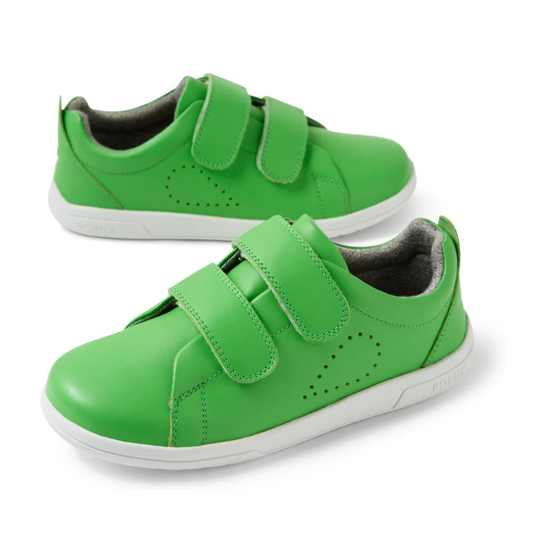 The Bobux KP Kids Plus Grass Court 2 II Leather Sneaker Retro Green is a pair of bright green leather sneakers for kids, featuring wide fit, white soles, and two Velcro straps on each shoe. The sneakers are displayed at an angle against a white background