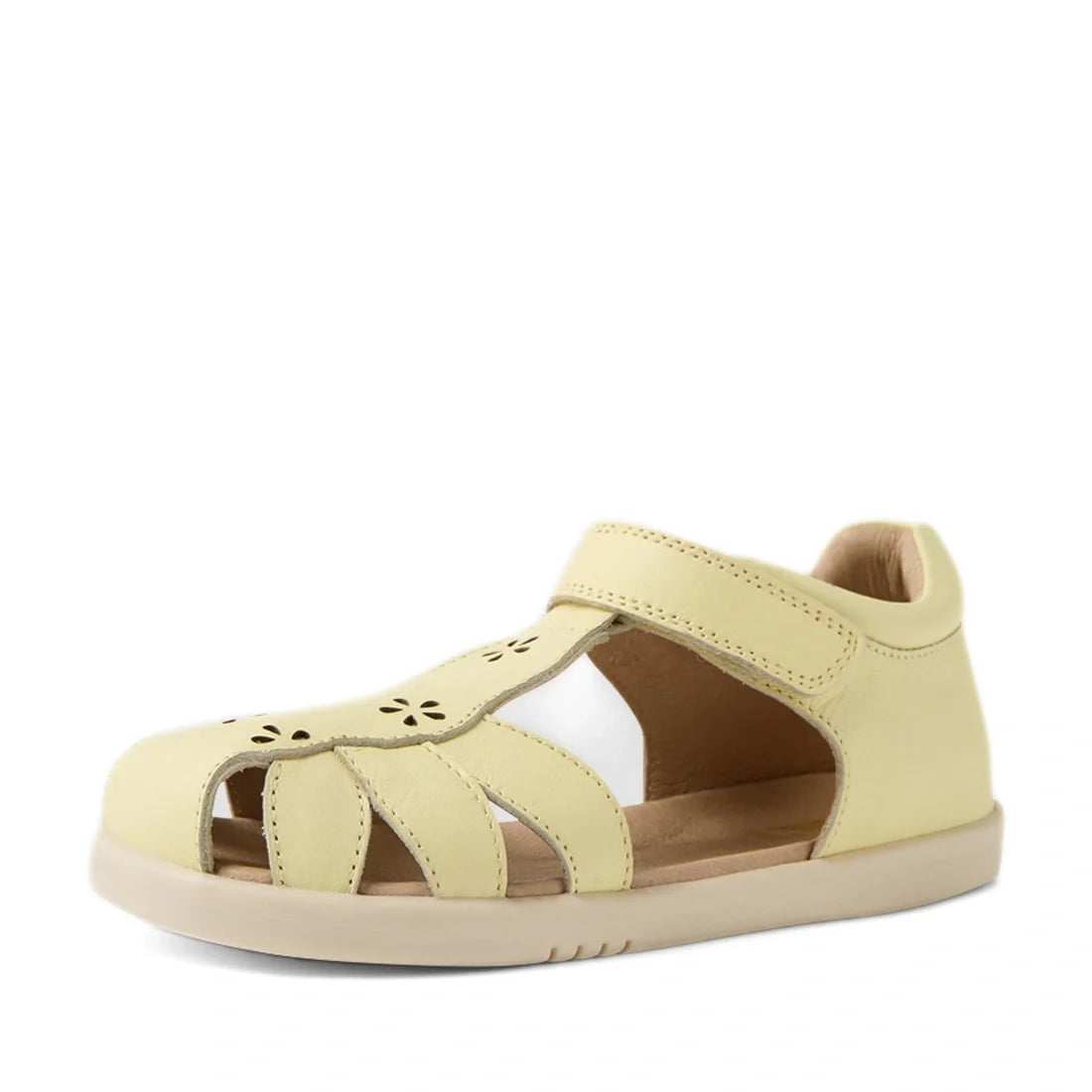 Introducing the Bobux Kid+ Plus KP Holly Wax Yellow Closed Toe Sandal—a light yellow children’s sandal crafted from leather and designed with cut-out sides, delicate flower-shaped perforations on the toe, a closed heel for support, and a convenient velcro