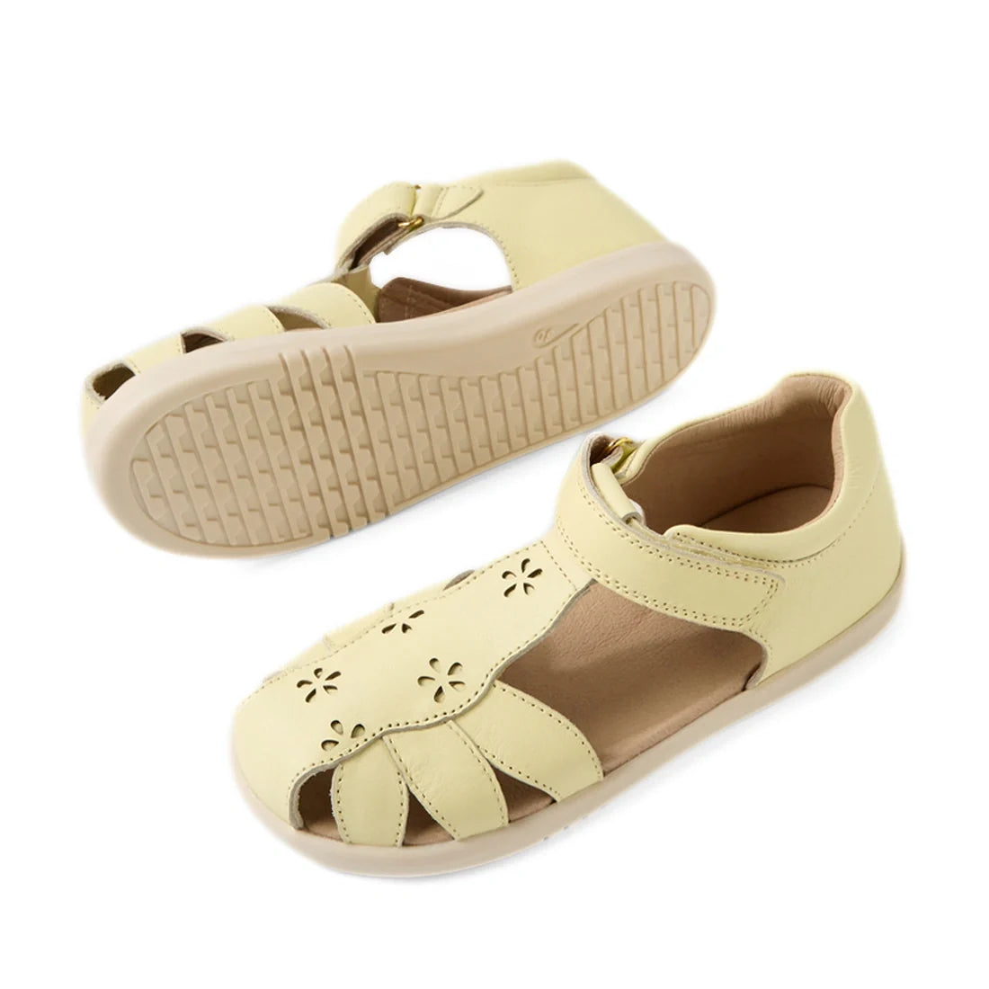 Two Bobux Kid+ Plus KP Holly Wax Yellow Closed Toe Sandals with cut-out floral patterns, Velcro straps, and textured rubber soles are shown: one displays the top view, while the other shows the sole., 9420074846785, 9420074846792, 9420074846808, 942007484