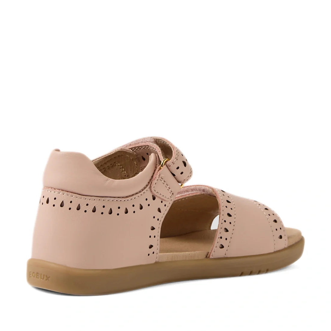 These charming Bobux Kid+ Plus KP Logan Cameo Rose Pink Open Toe Sandals for girls feature a light pink leather upper with decorative cutouts, a covered heel, open toe, adjustable strap, and a light brown rubber sole. Shown from a rear side angle, they of