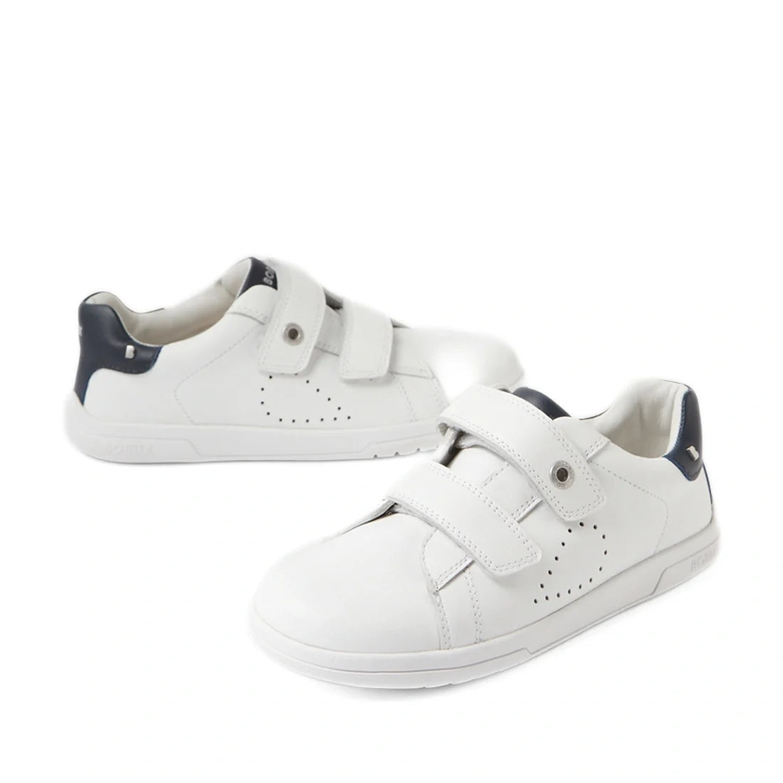A pair of Bobux Kid+ Plus KP Maverick Leather Sneaker White Navy shoes, featuring white leather with navy accents and adjustable hook-and-loop Velcro straps, displayed on a white background.