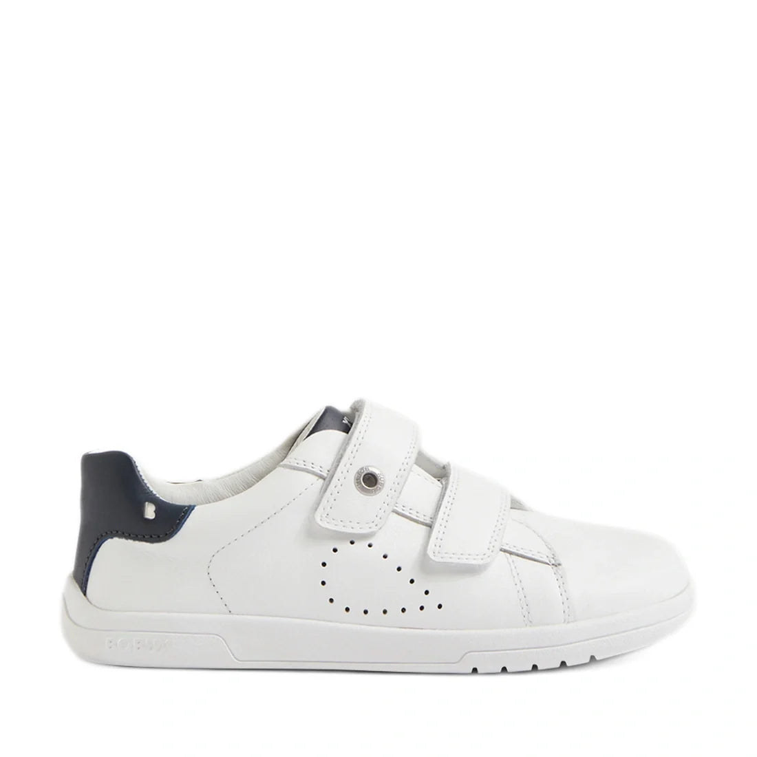 The Bobux Kid+ Plus KP Maverick Leather Sneaker in White Navy features white leather, two adjustable Velcro straps, subtle side perforations, and a dark blue heel accent. Designed for kids, these sneakers have a low profile and a flat rubber sole.