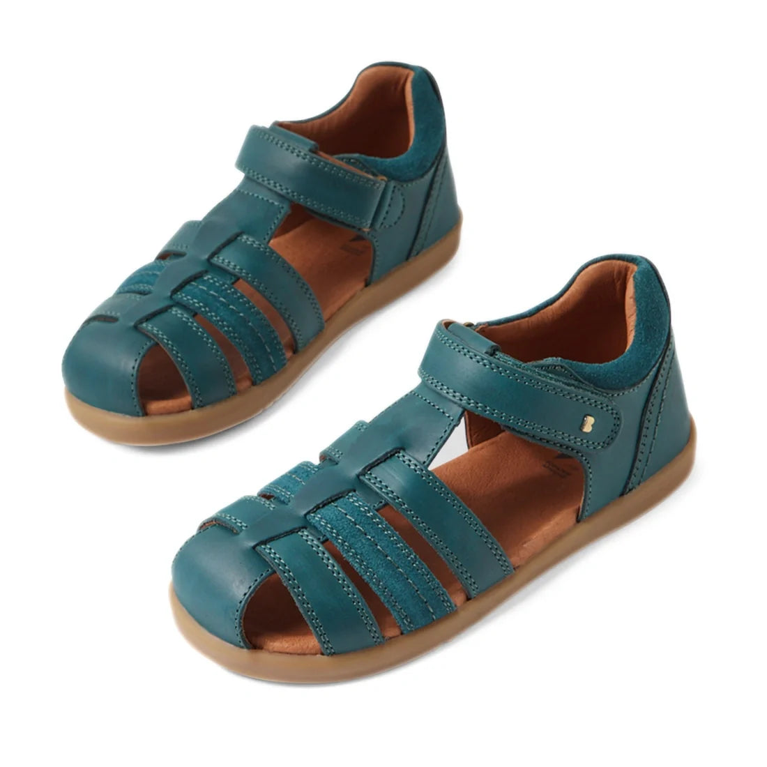 A pair of Bobux Kid+ Plus Roam Mediterranean Green Closed Toe Sandals for kids, featuring brown soles and adjustable Velcro straps, displayed on a white background.