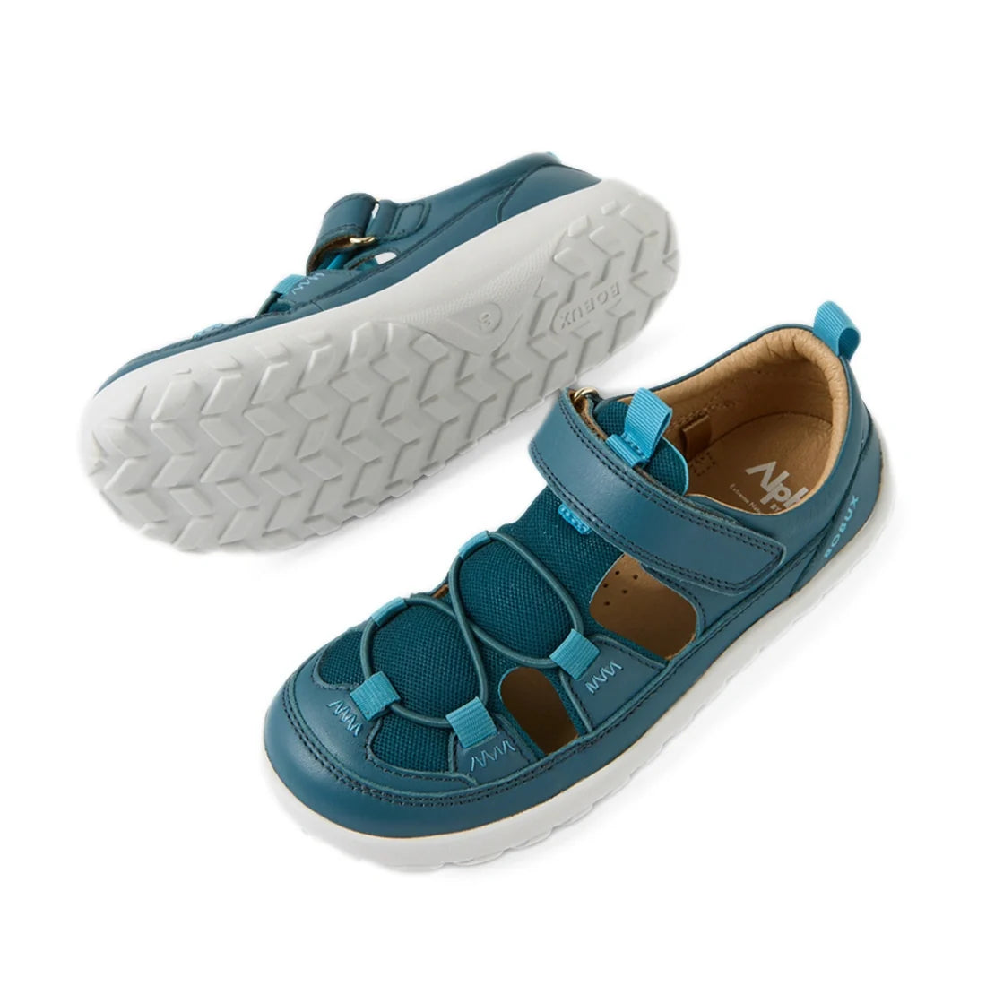 Two Bobux Kid+ KP Rocky Leather Closed Toe Sandals in Mediterranean Green, featuring mesh panels and a Velcro strap across the top. One sandal is shown facing up and the other displays its white textured sole. These barefoot sandals offer kids a comfortab
