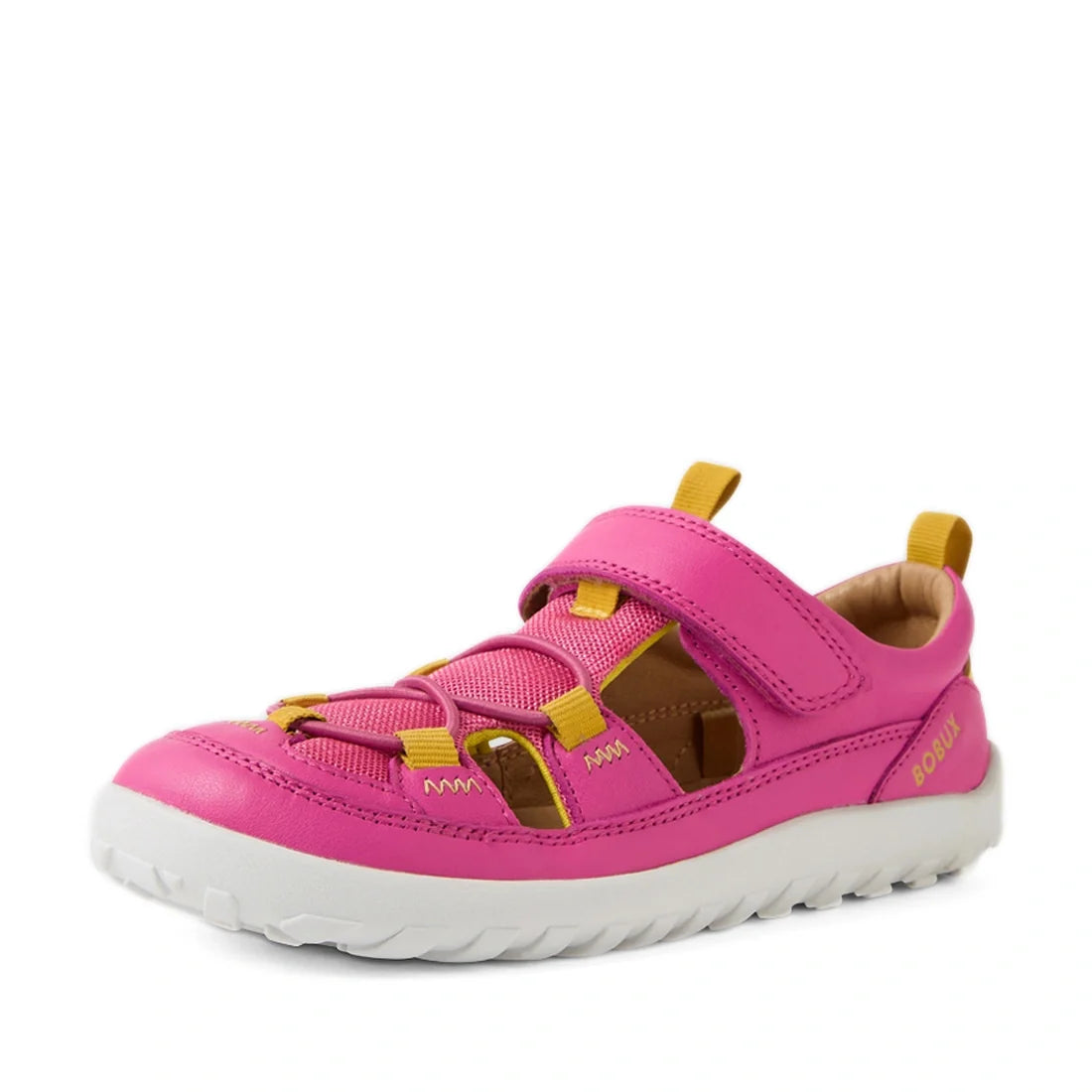 A Bobux Kid+ KP Rocky Leather Closed Toe Sandal in Rose Violet is shown at an angle on a white background; this kids’ sandal features pink and yellow leather, a white sole, Velcro strap, cutouts for breathability, and a barefoot-like zero drop constructio