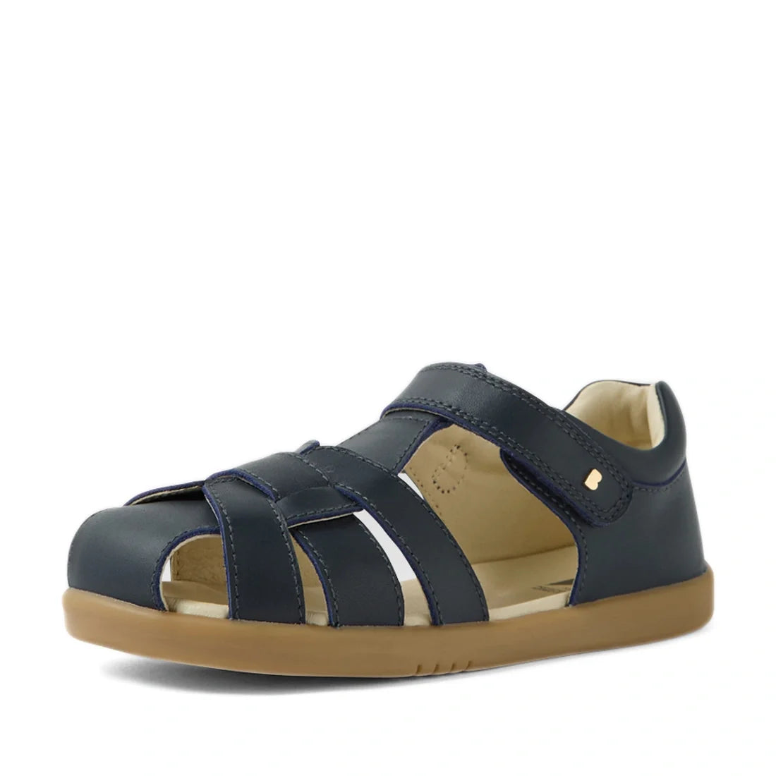 Introducing the Bobux Kids Plus KP Skip Twist Navy Closed Toe Sandal—a navy blue leather sandal featuring a closed toe, velcro strap, and tan rubber sole. These kids’ sandals are perfect for children looking for comfortable and breathable summer footwear.