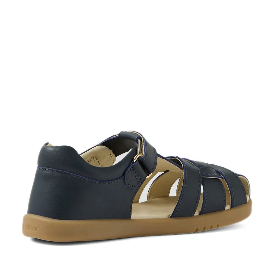 The Bobux Kids Plus KP Skip Twist Navy Closed Toe Sandal is a children’s navy leather sandal featuring a closed heel, tan rubber sole, open toe design for breathability, and an adjustable Velcro strap, shown at an angle on a white background., 94200748484