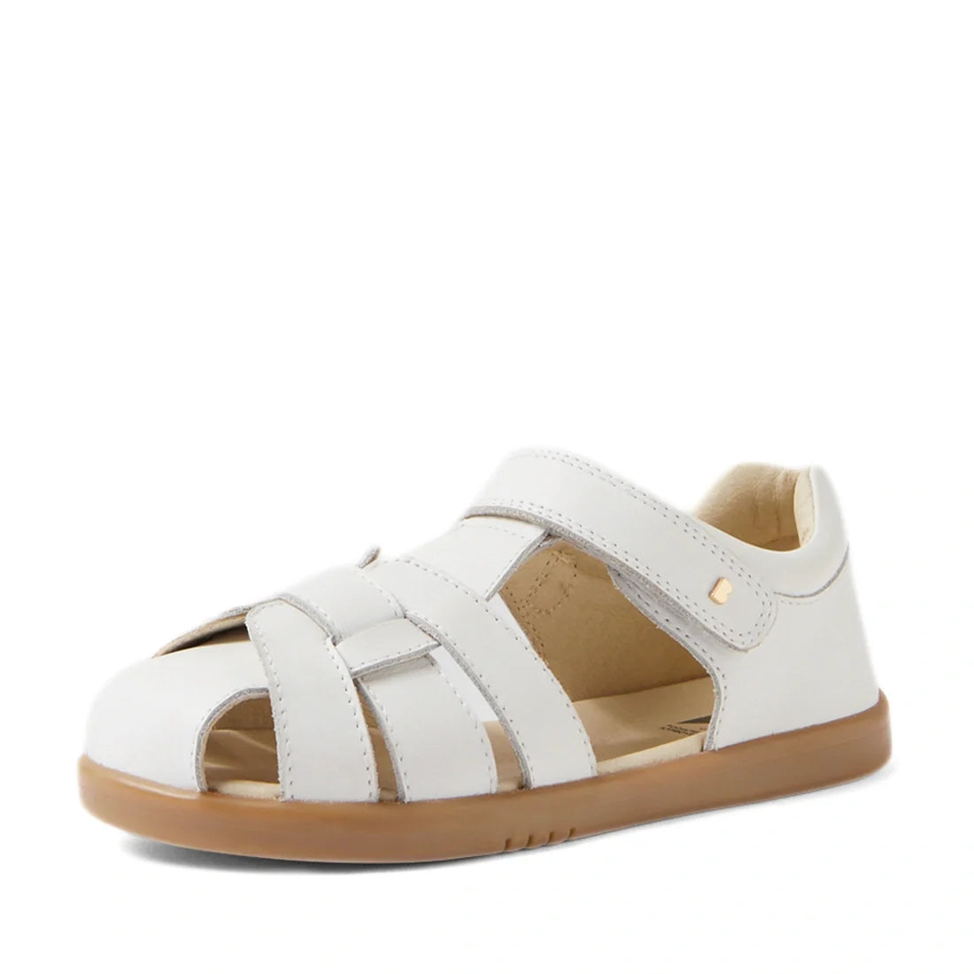 The Bobux Kids Plus KP Skip Twist White Closed Toe Sandal is a classic children’s sandal crafted from white leather, featuring closed toes, open sides, a tan rubber sole, and an adjustable Velcro strap for easy wear. Designed to provide both comfort and d