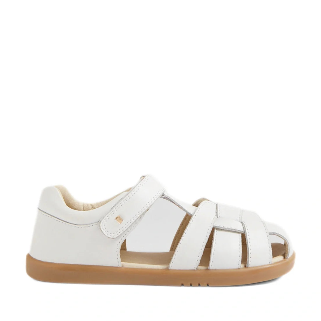 The Bobux Kids Plus KP Skip Twist White Closed Toe Sandal features a white leather upper, closed heel, open toe, tan rubber sole, and Velcro strap, shown from the side against a plain white background—ideal for those looking for comfortable and stylish ch