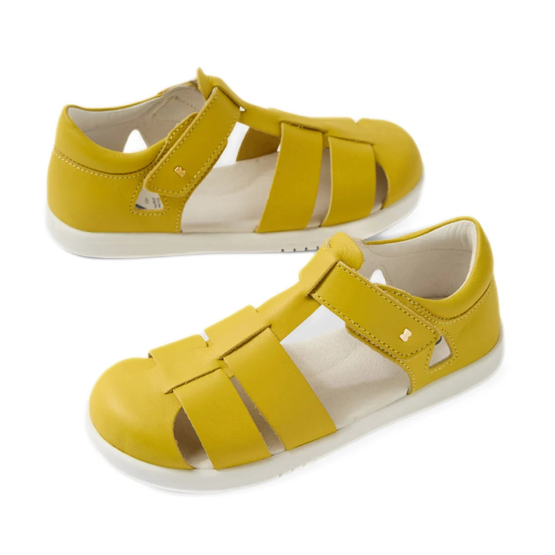 A pair of Bobux Kid + Plus Tidal Closed Toe Quick Dry Sandal Mango Mint kids’ sandals featuring closed toes, yellow leather uppers, white soles, and a hook-and-loop strap on each shoe.