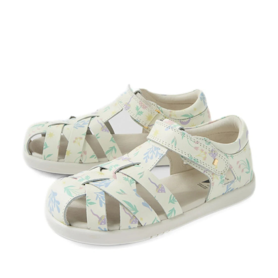 Introducing the Bobux Kids Plus KP Tropicana II White Floral Quick Dry Sandal—a pair of closed-toe kids sandals with white soles and pretty pastel floral patterns. Crafted from quick-dry leather, these sandals feature adjustable ankle straps to provide bo