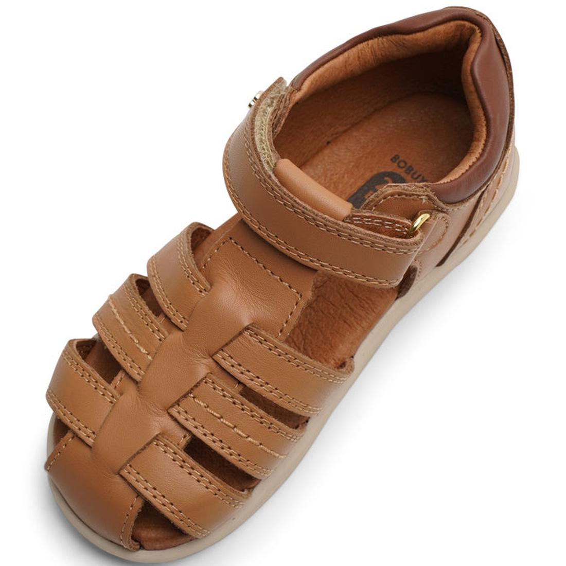 A single Bobux IWalk Roam Sandal Caramel Toffee kids sandal with a closed toe, woven leather straps, and hook-and-loop ankle strap is displayed on a white background., 9420071319169, 9420071319176, 9420071319183, 9420071319190, 9420071319206