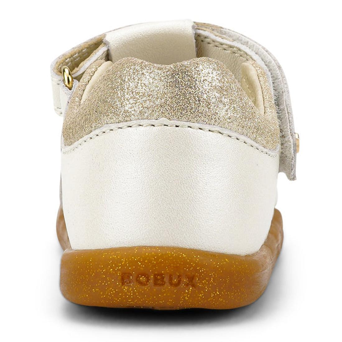 A close-up rear view of the Bobux iwalk Cross Jump Sandal Moon Pearl Closed Toe 636708 shows a gold glitter heel, white leather upper, brown rubber sole, Velcro strap, and "BOBUX" embossed on the heel., 9420068516335, 9420068516342, 9420068516359, 9420068
