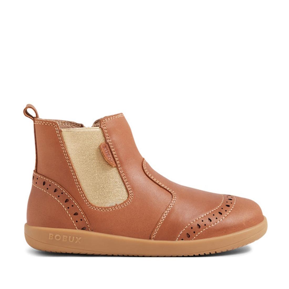 The Bobux Kid+ KP Billie 2 II Girls Leather Boot in Caramel Tan is a kids ankle boot featuring brogue detailing, elastic side panel, pull tab, and flexible sole. BOBUX is embossed on the light brown rubber sole—ideal for everyday wear., 9420074867179, 942
