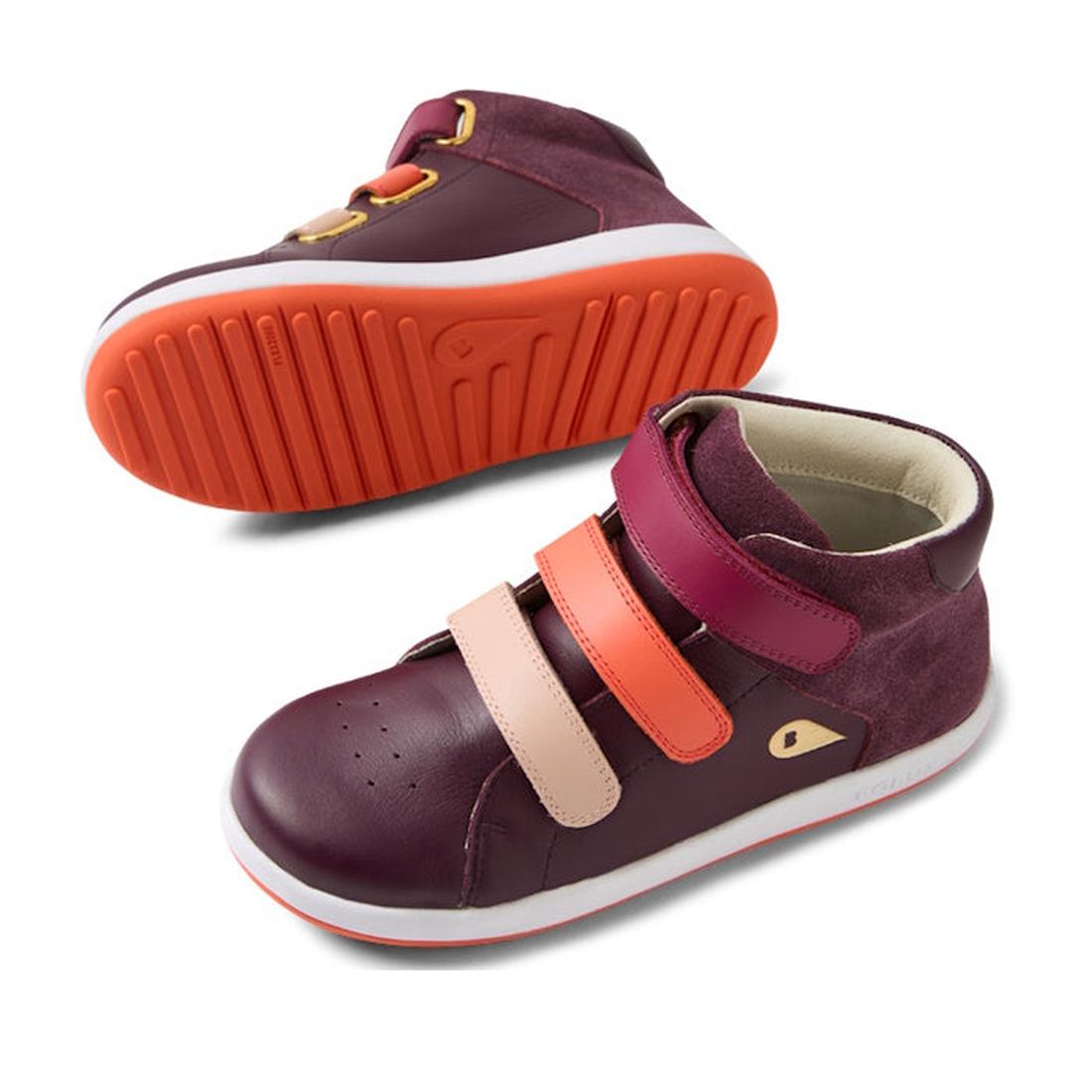The Bobux KP Kids Plus Juniors Gamepoint Leather Boot in Fig Purple features two children's sneakers with pink and orange adjustable straps, white rubber soles, and orange tread; one shoe is upright, the other shows the sole., 9420074815330, 9420074815347