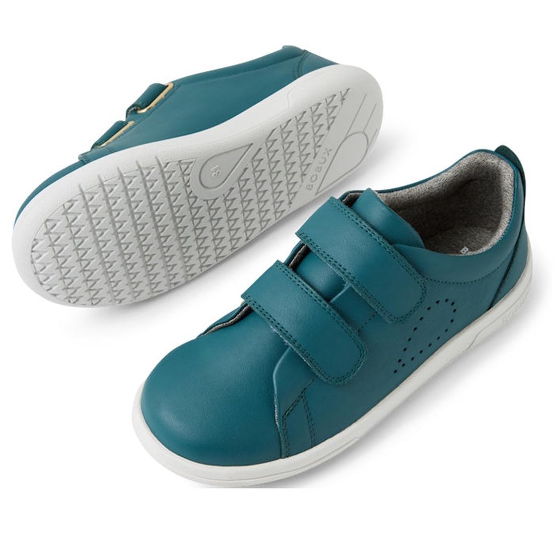 A pair of Bobux KP Kids Plus Grass Court 2 II Leather Sneakers in Mediterranean Green with white durable soles. One shoe stands upright showing two adjustable straps, while the other displays the textured sole., 9420074859303, 9420074859310, 9420074859327