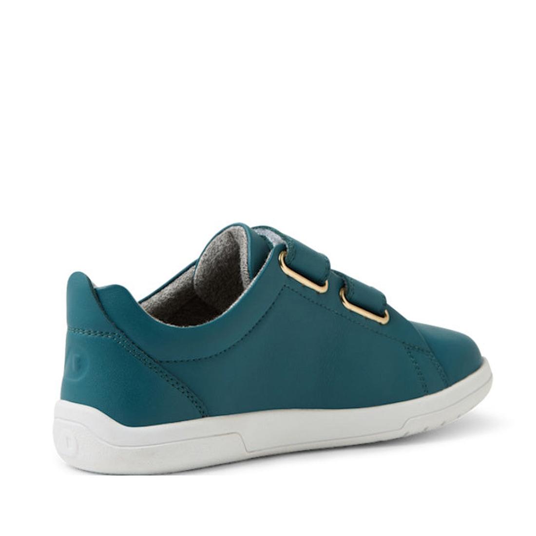 The Bobux KP Kids Plus Grass Court 2 II Leather Sneaker in Mediterranean Green is a low-cut kids’ shoe with a smooth finish, adjustable Velcro straps, gold eyelets, and a white durable sole, shown angled from the back right side., 9420074859303, 942007485