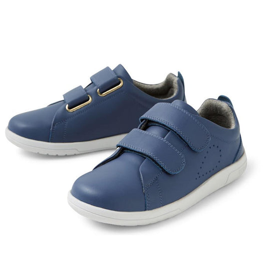 The Bobux KP Kids Plus Grass Court II Leather Sneaker in Vintage Indigo Blue features white soles, Velcro straps, and a simple modern design with smooth leather material—perfect for stylish kids.