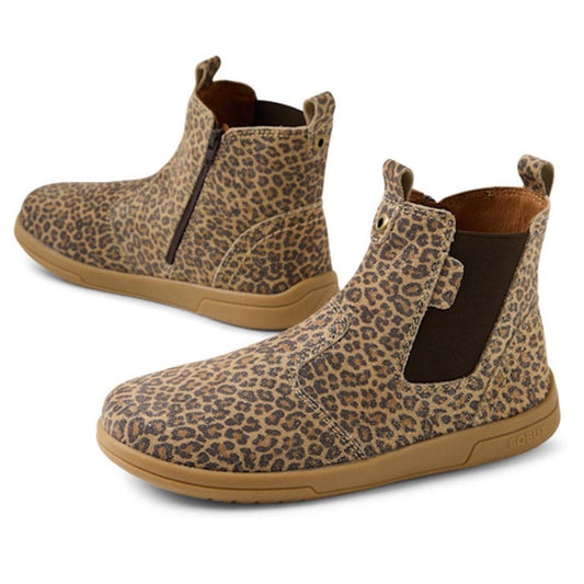 The Bobux KP Kids Plus Jodhpur II Juniors Leather Boot features ankle-high leopard shimmer leather, brown elastic side panels, side zippers, and tan rubber soles, with both outer and inner sides visible.
