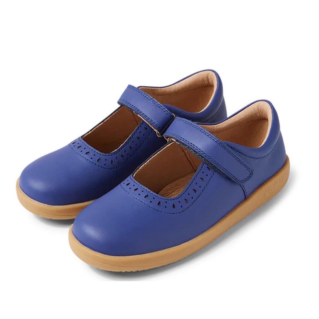 The Bobux Kid+ Lola Girls Mary Jane Leather in Future Dusk Blue/Purple (850802) features a Velcro strap, tan rubber soles, and brogue-inspired cut-out details along the strap and toe opening.