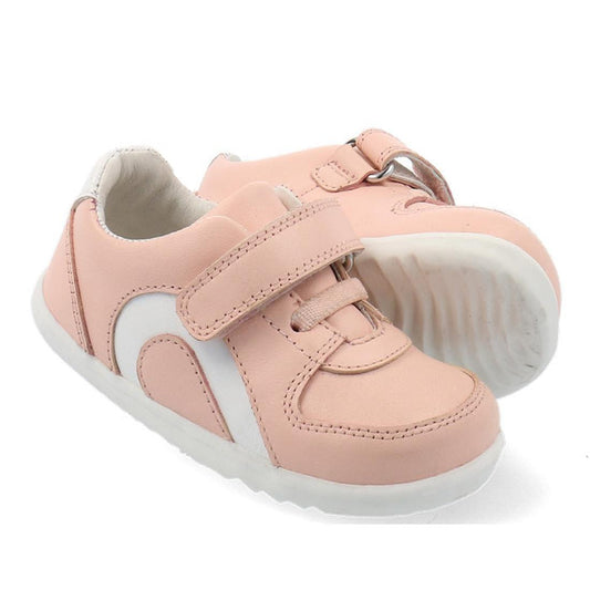 The Bobux Step Up SU Toddlers Leather Sneaker Comet Pink 734604 features light pink leather, a flexible sole, and hook-and-loop straps. One shoe is positioned in front at an angle, with the other slightly behind.