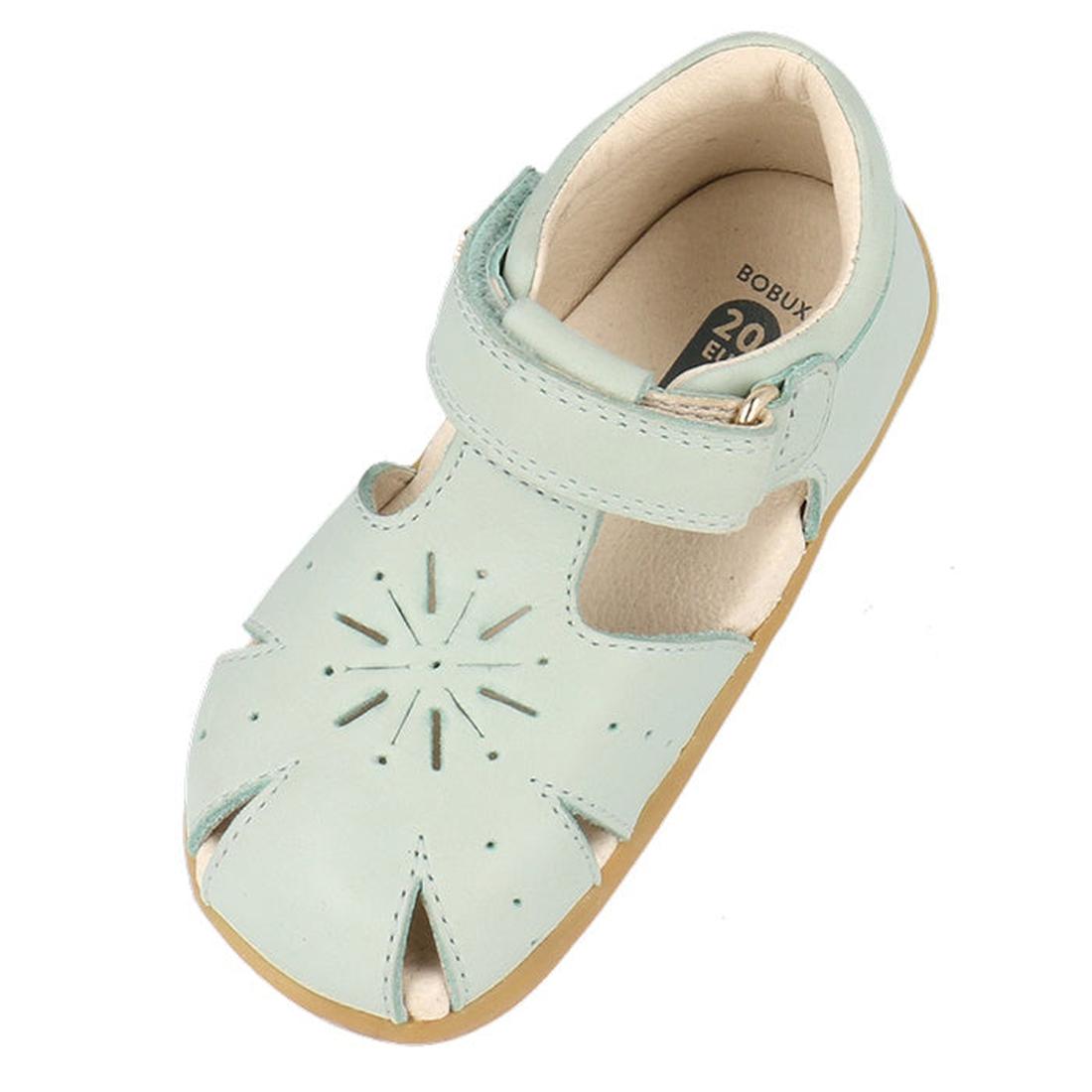 The Bobux Step Ups Compass Mist Aqua 734905 is a toddler girls' first walker sandal in light blue, featuring a closed toe, starburst cut-out design, adjustable hook-and-loop strap, beige lining, and light brown sole—ideal leather shoes for toddlers., 9420, 9420075708594, 9420075708600, 9420075708617, 9420075708624
