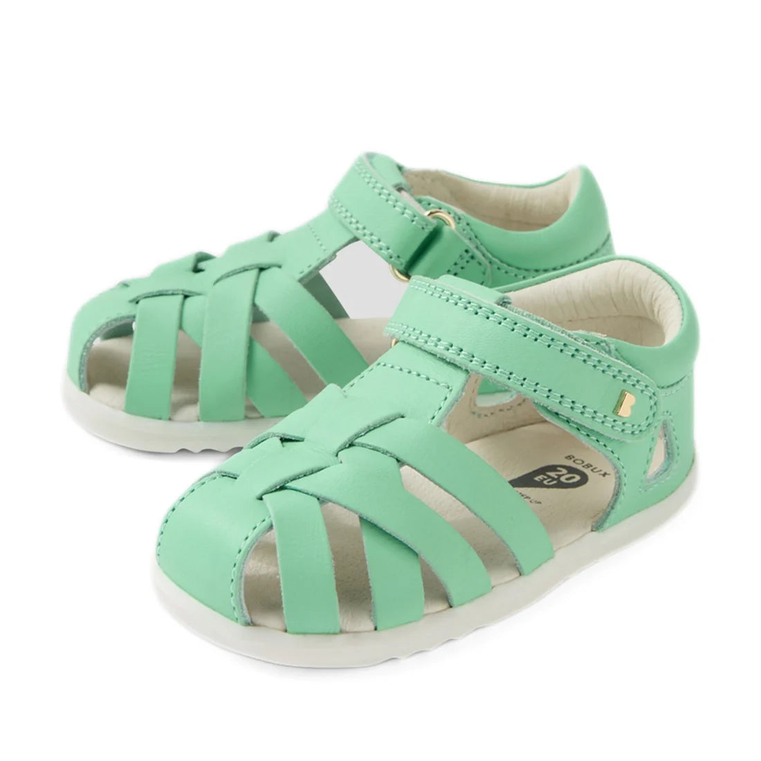 A pair of Bobux Step Up SU Tropicana II Mint Jelly Green closed toe sandals for toddlers, featuring woven leather straps and adjustable hook-and-loop ankle straps.