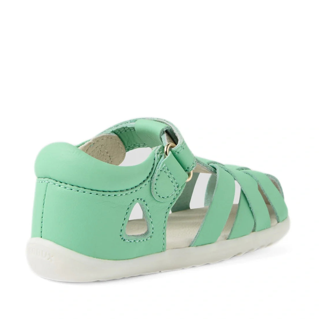 The Bobux Step Up SU Tropicana II Mint Jelly Green Closed Toe Sandal is a children’s sandal in mint green, featuring a closed heel, open sides, and an adjustable Velcro strap as seen from a rear side angle. These stylish leather sandals for toddlers inclu