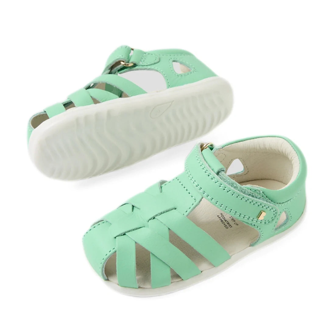 A pair of Bobux Step Up SU Tropicana II Mint Jelly Green Closed Toe Sandals for toddlers, featuring woven leather straps, a closed heel, an open toe, and durable white rubber soles. These stylish sandals include a Velcro closure for easy on and off., 9420
