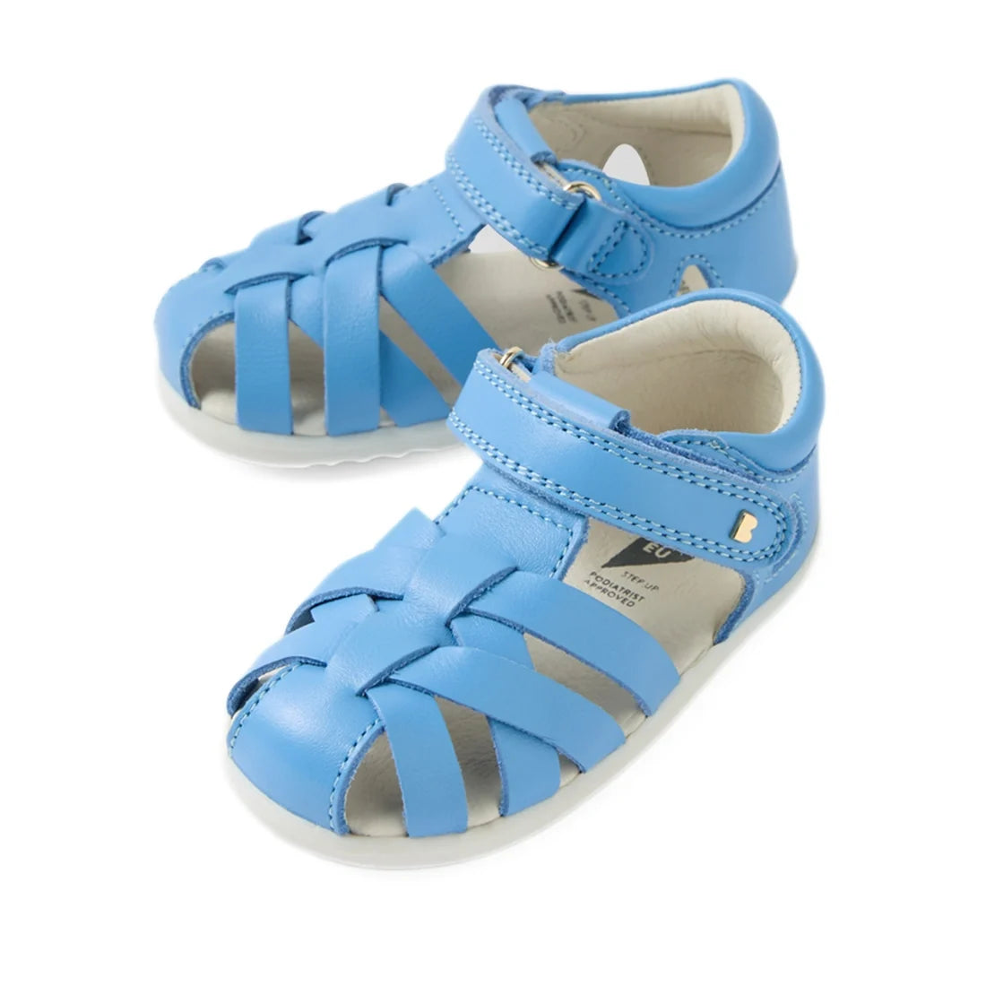 A pair of Bobux Step Up SU Tropicana II Baltic Sea Blue Closed Toe Sandals for babies, featuring closed toes, open sides, and a Velcro strap across the ankle, displayed against a white background.