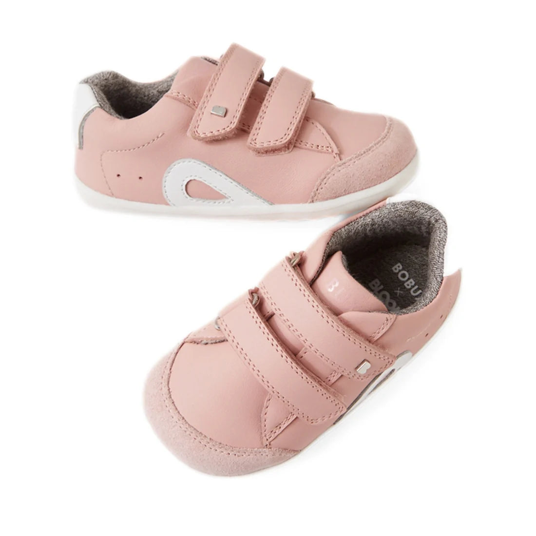 The Bobux SU Step Up Blaze Leather Toddlers Sneaker in Ballet Pink features white and gray accents, two Velcro straps, and soft soles—perfect as first walking shoes for toddlers—shown here on a white background.