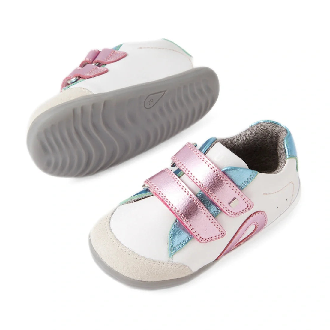 Featured here are two Bobux SU Step Up Blaze Leather Toddlers Sneakers in White Pink, designed for first walkers. Each kids’ leather sneaker boasts pink, blue, and teal accents, a gray rubber sole, and two metallic pink hook-and-loop straps. One shoe is u